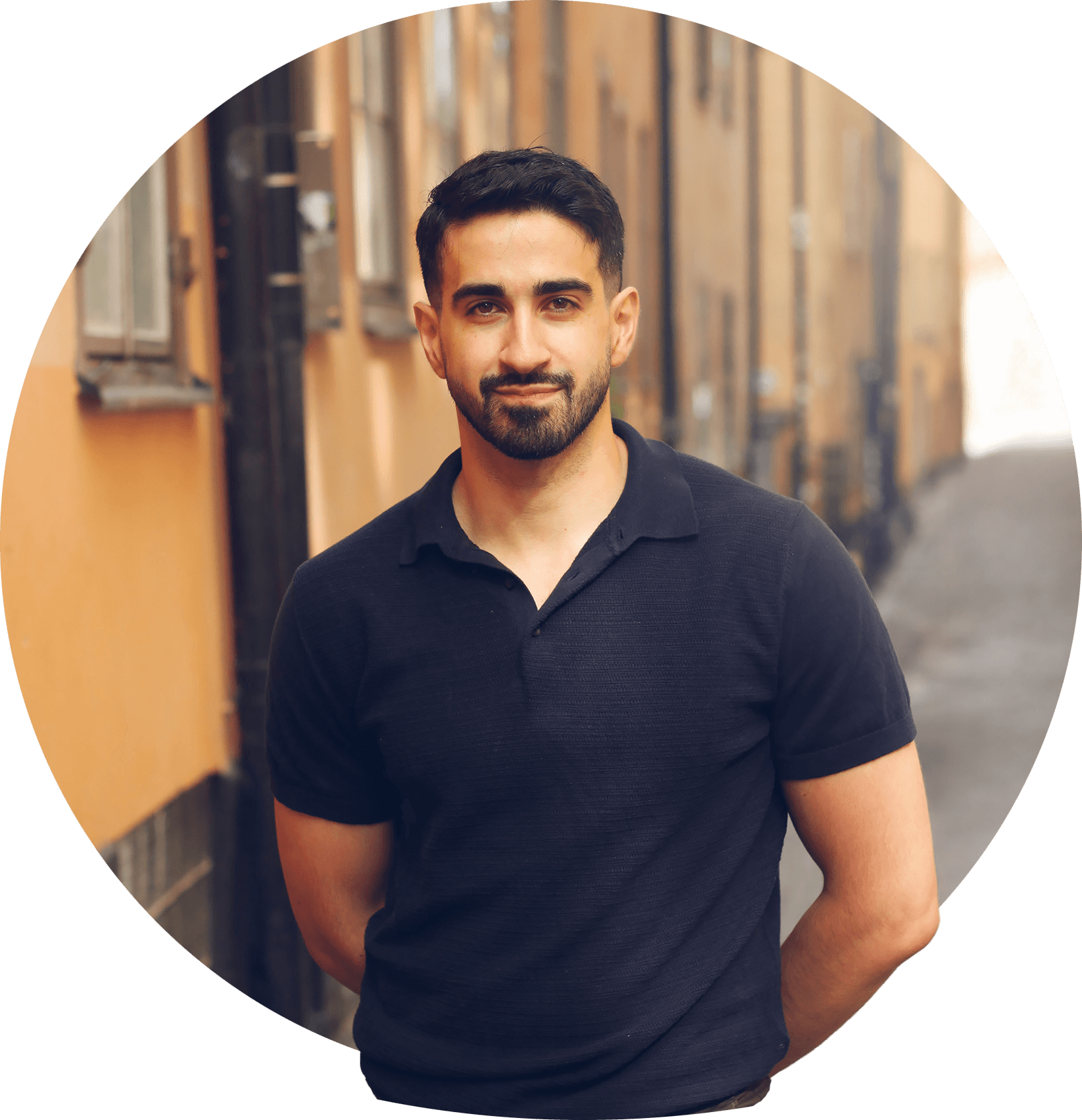 Melad med bredt smil, svart hår og skjegg, kledd i svart skjorte. Foto.